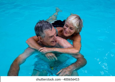 Smiling Senior Couple Enjoying In Swimming Pool