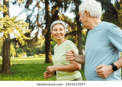 Smiling senior couple jogging in the park. Lifestyle, people and sport concept. - Powered by Shutterstock