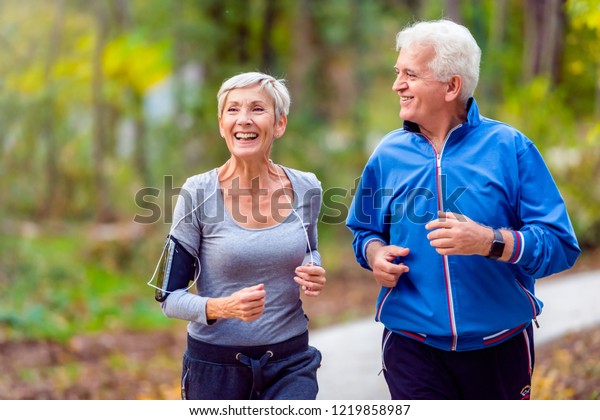 Smiling senior couple\
jogging in the park