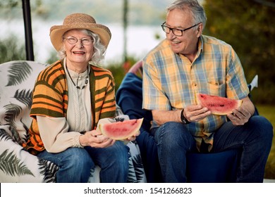 Smiling Senior Couple On Romantic Vacation Eating Watermelon