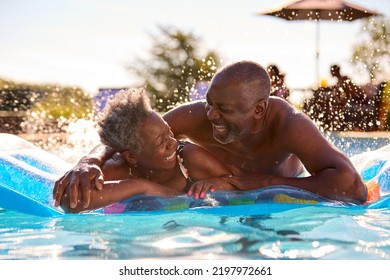 Smiling Senior Couple On Summer Holiday Relaxing In Swimming Pool On Inflatable - Powered by Shutterstock