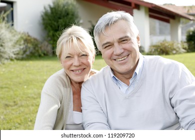 Smiling senior couple sitting in garden