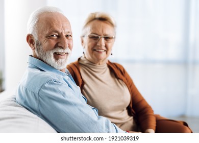 Smiling senior couple  sitting at home. There are looking at camera - Powered by Shutterstock