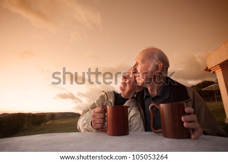 Smiling senior couple sitting outside at sunset