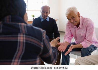 Smiling Senior Friends Discussing While Sitting In Art Class