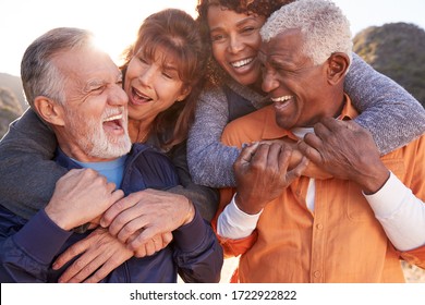 Smiling Senior Friends Having Fun Walking In Countryside Together