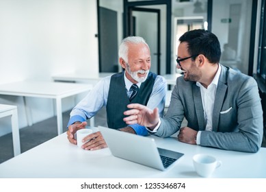 Smiling Senior And Junior Business Men At Work.