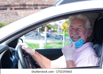 Smiling Senior Man With Protective Gloves Driving Silver Car Moves Away From Face Mask Against Coronavirus - New Normal Life Until End Of Pandemic