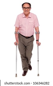Smiling senior man walking with two crutches. All on white background