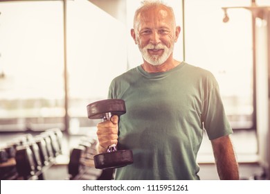 Smiling senior man with weight at gym. Looking at camera. - Powered by Shutterstock