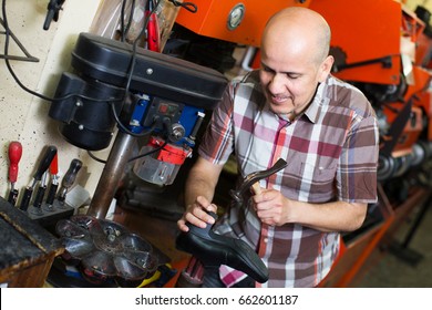 Smiling Senior Specialist Fixing Heel Taps Of Shoes On Machine