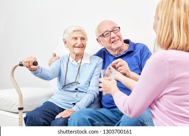 Smiling senior is taking tablet with water in senior home or at home