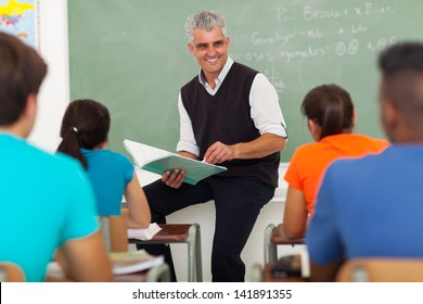 Smiling Senior Teacher Teaching Group Of High School Students In Classroom