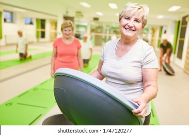 Smiling Senior Woman With The Bosu Ball In A Physiotherapy Course As A Rehab Sport