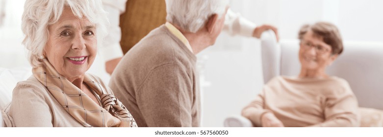 Smiling Senior Woman And Her Friends Chatting In A Retirement Home