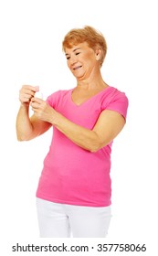 Smiling Senior Woman Holding Jar Of Pills.