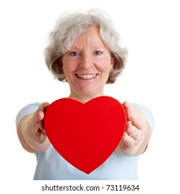 Smiling Senior Woman Offering A Red Heart