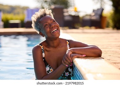 Smiling Senior Woman On Summer Holiday Relaxing In Swimming Pool