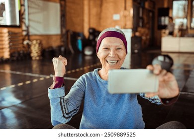 Smiling senior woman taking selfie in gym - Powered by Shutterstock