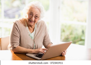 Smiling Senior Woman Using Laptop At Home