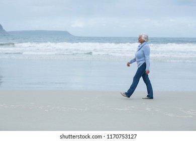 Smiling Senior Woman Walking On The Beach