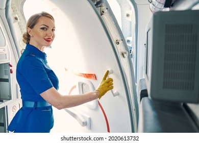 Smiling Slender Stewardess Opening The Door Of The Plane