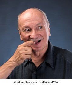 Smiling Sly Elderly Man On A Dark Background