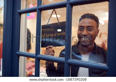 Smiling Small Business Owner Turning Around Back In 5 Minutes Sign On Shop Or Store Door