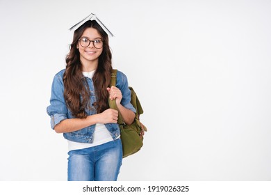 Smiling smart caucasian school girl with a book on her head isolated in white background