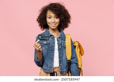 Smiling smart little african american kid school girl 12-13 years old in casual denim clothes with backpack hold credit bank card isolated on pastel pink background studio Childhood education concept - Powered by Shutterstock