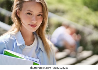 Smiling smart pretty happy blonde girl university or college student holding notebooks looking at camera standing outside campus. Close up portrait outdoors, education program course ads. - Powered by Shutterstock