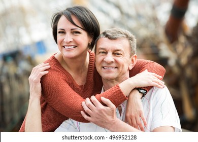 Smiling Spanish Adult Couple Hugging Outdoors At Sunny Spring Day