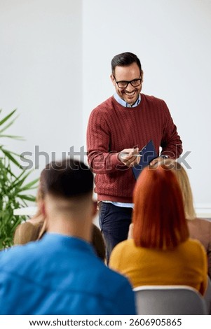 Smiling speaker interacts with audience while presenting concepts in casual environment.