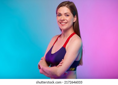 Smiling Sporty Woman In Fitness Sportswear With Arms Crossed. Confident Female Fitness Coach Portrait Isolated On Neon Multicolor Background.