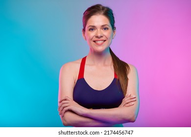 Smiling Sporty Woman In Fitness Sportswear With Arms Crossed. Confident Female Fitness Coach Portrait Isolated On Neon Multicolor Background.