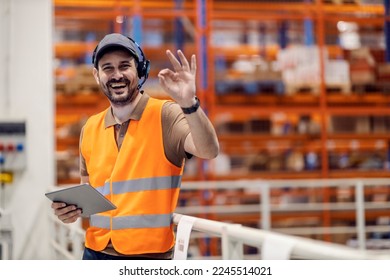 Smiling storage supervisor is gesturing okay sign for excellent organization in logistics. - Powered by Shutterstock