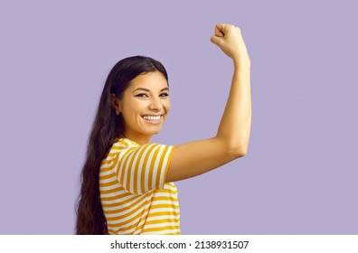 Smiling Strong Ethnic Woman Isolated On Purple Studio Background Show Muscles And Power. Happy Powerful Girl Demonstrate Strength And Leadership. Women Can Do It.