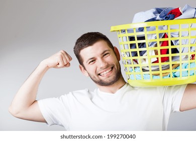 A smiling strong handsome man doing the laundry - Powered by Shutterstock