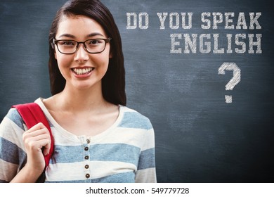 Smiling student with backpack standing in library against blue chalkboard - Powered by Shutterstock