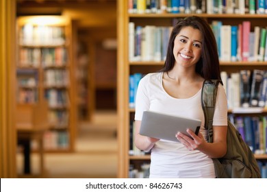 Smiling student using a tablet computer in a library - Powered by Shutterstock