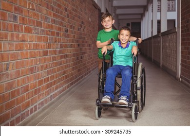 Smiling student in a wheelchair and friend beside him on the elementary school grounds - Powered by Shutterstock