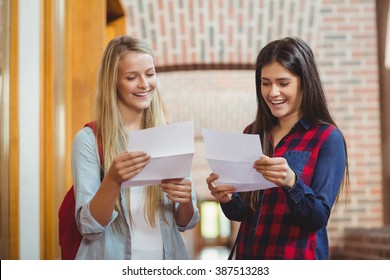 Smiling Students Looking At Results At University