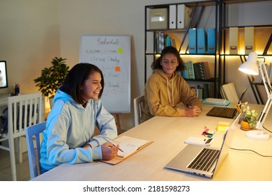 Smiling Students Studying In Common Room Of College Dorm