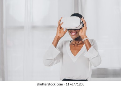 smiling stylish african american businesswoman in virtual reality headset in office - Powered by Shutterstock