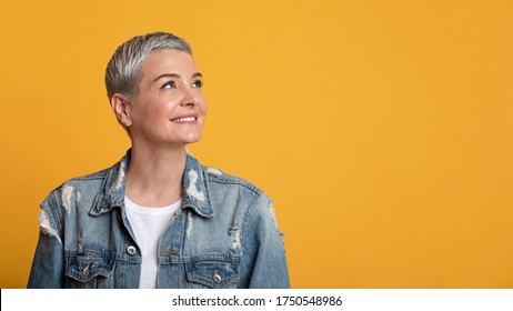 Smiling Stylish Middle-Aged Woman Lokking Upwards At Copy Space On Yellow Background With Interest, Panorama - Powered by Shutterstock