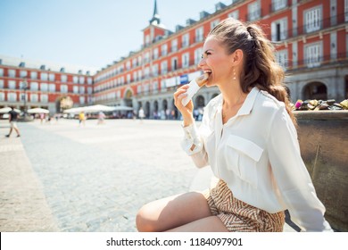 Smiling Stylish Woman At Plaza Mayor Eating Empanada