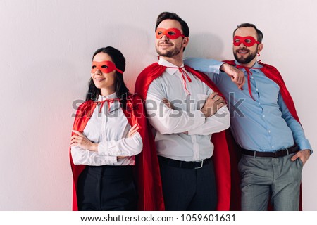 smiling super businesspeople in masks and capes looking away isolated on white