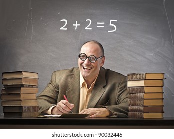 Smiling teacher in a classroom with wrong calculation on the blackboard in the background