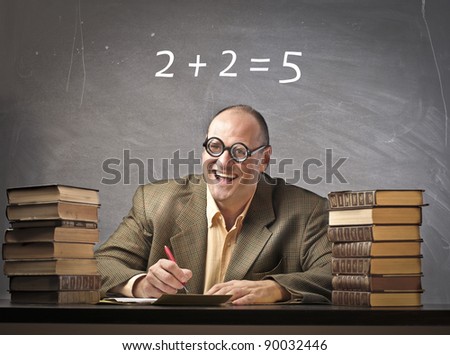 Smiling teacher in a classroom with wrong calculation on the blackboard in the background