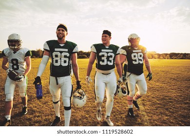 Smiling Team Of Young American Football Players Walking Off A Field Together After A Practice Game On A Sunny Afternoon